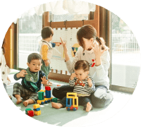 子供と先生が室内で一緒に遊んでいる写真